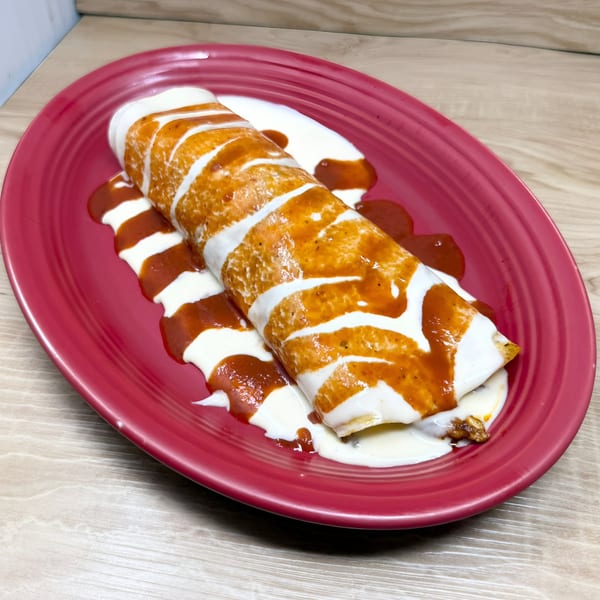 Don Tequila Bar & Grill's Mexican burrito, topped with red sauce and sour cream, on a red plate.
