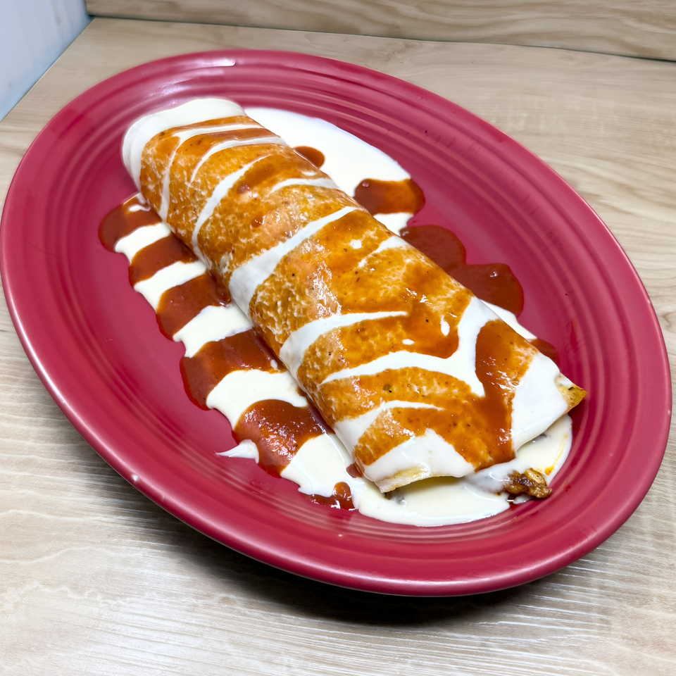 Don Tequila Bar & Grill's Mexican burrito, topped with red sauce and sour cream, on a red plate.